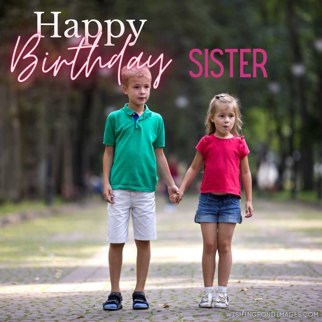 Two cute young blonde smiling children, brother, and sister holding hands on a bright sunny summer d